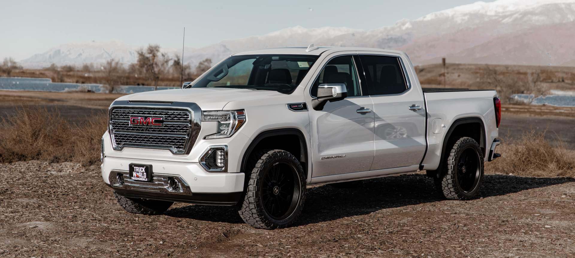 Newer used GMC Sierra sitting on icy patch of a dirt road in Utah.