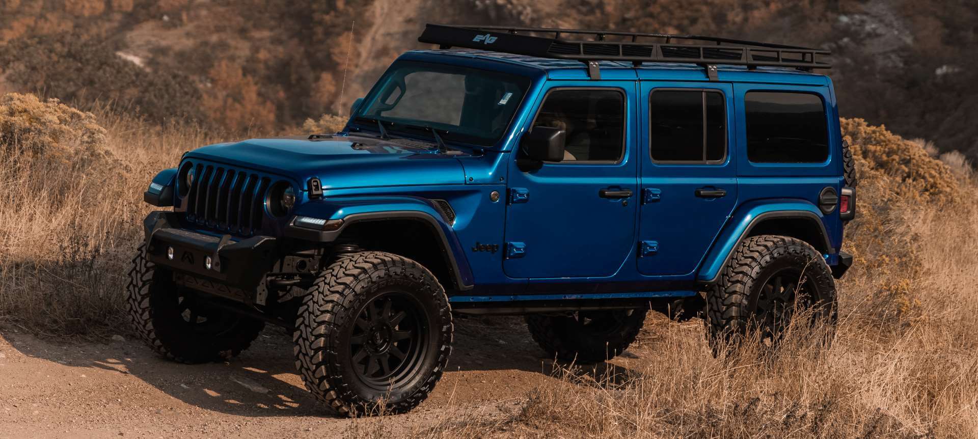 Used Jeep off-roading beside tall grasses in Utah in autumn.