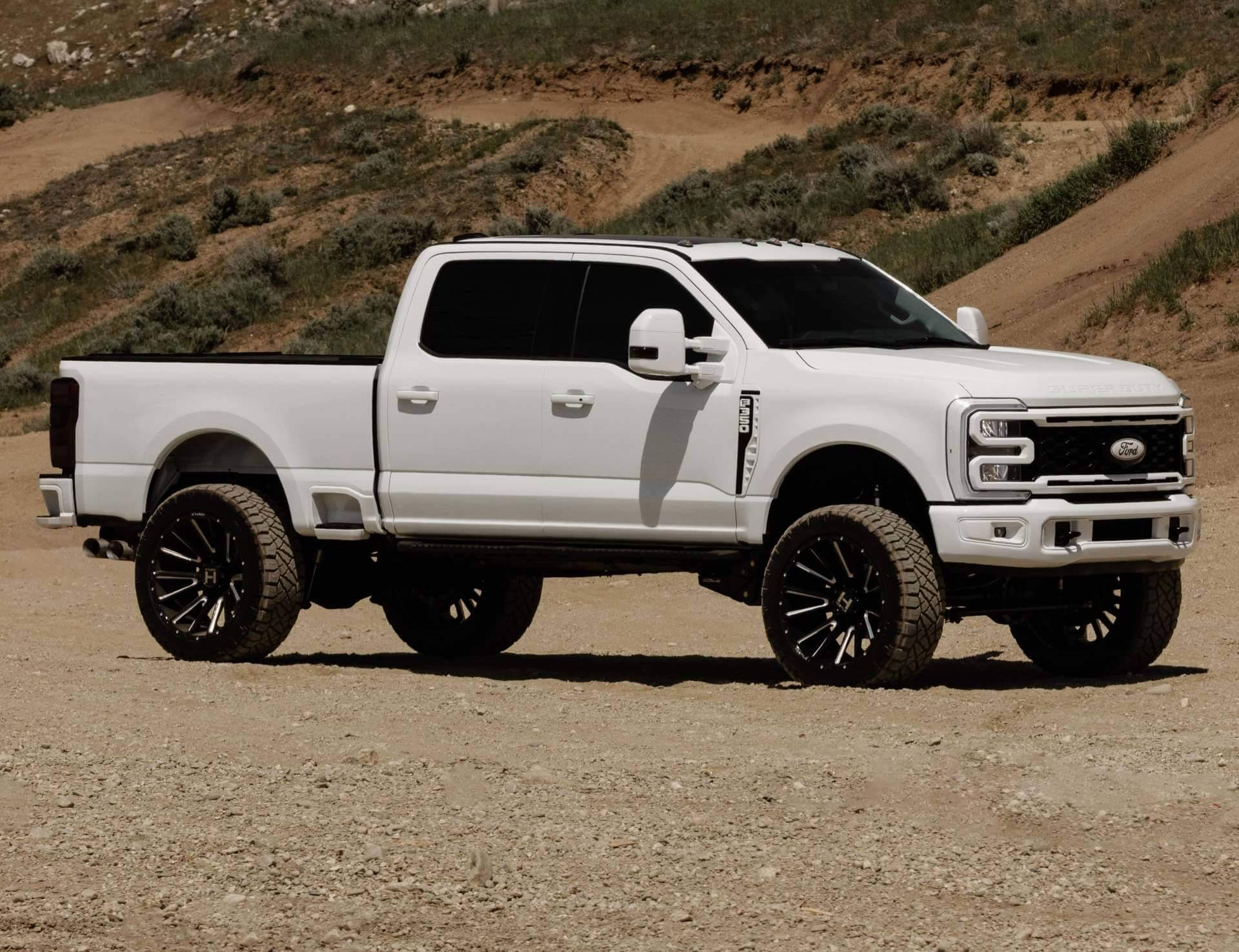 Capture the rugged beauty of a lifted Ford F 350 in white, conquering the Rocky Mountains with ease.