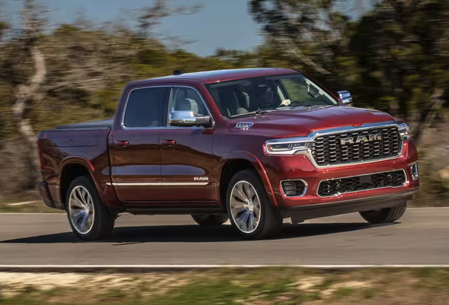 Red Ram 1500 driving down a road