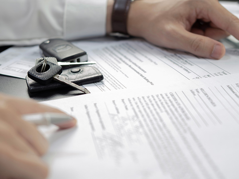 Customer reviewing loan terms on a contract before purchasing a new vehicle