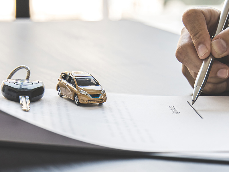 Customer signing paperwork to purchase a new vehicle