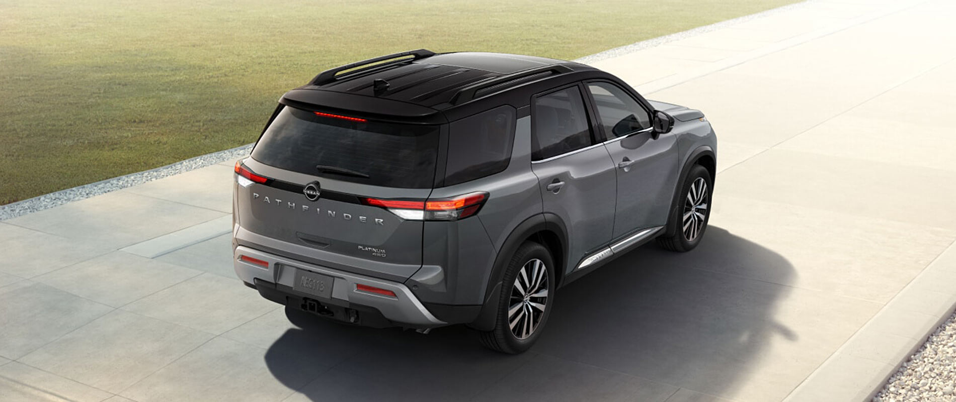 A gray Nissan Pathfinder driving down a clear road