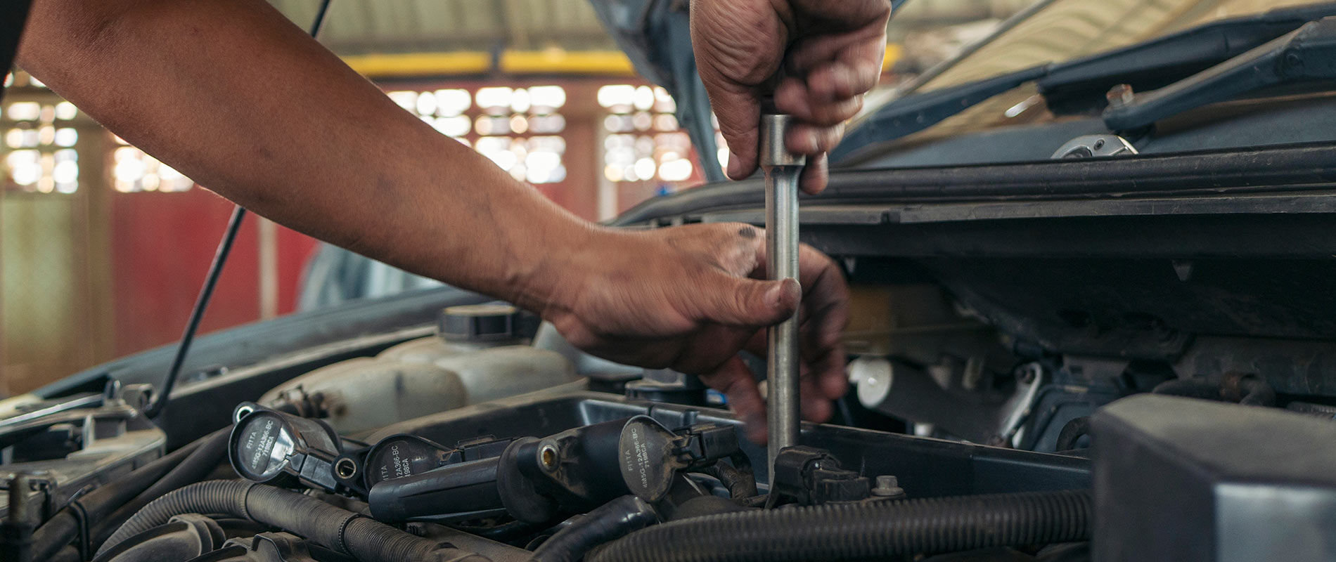 Engineer repairing vehicle under the hood.