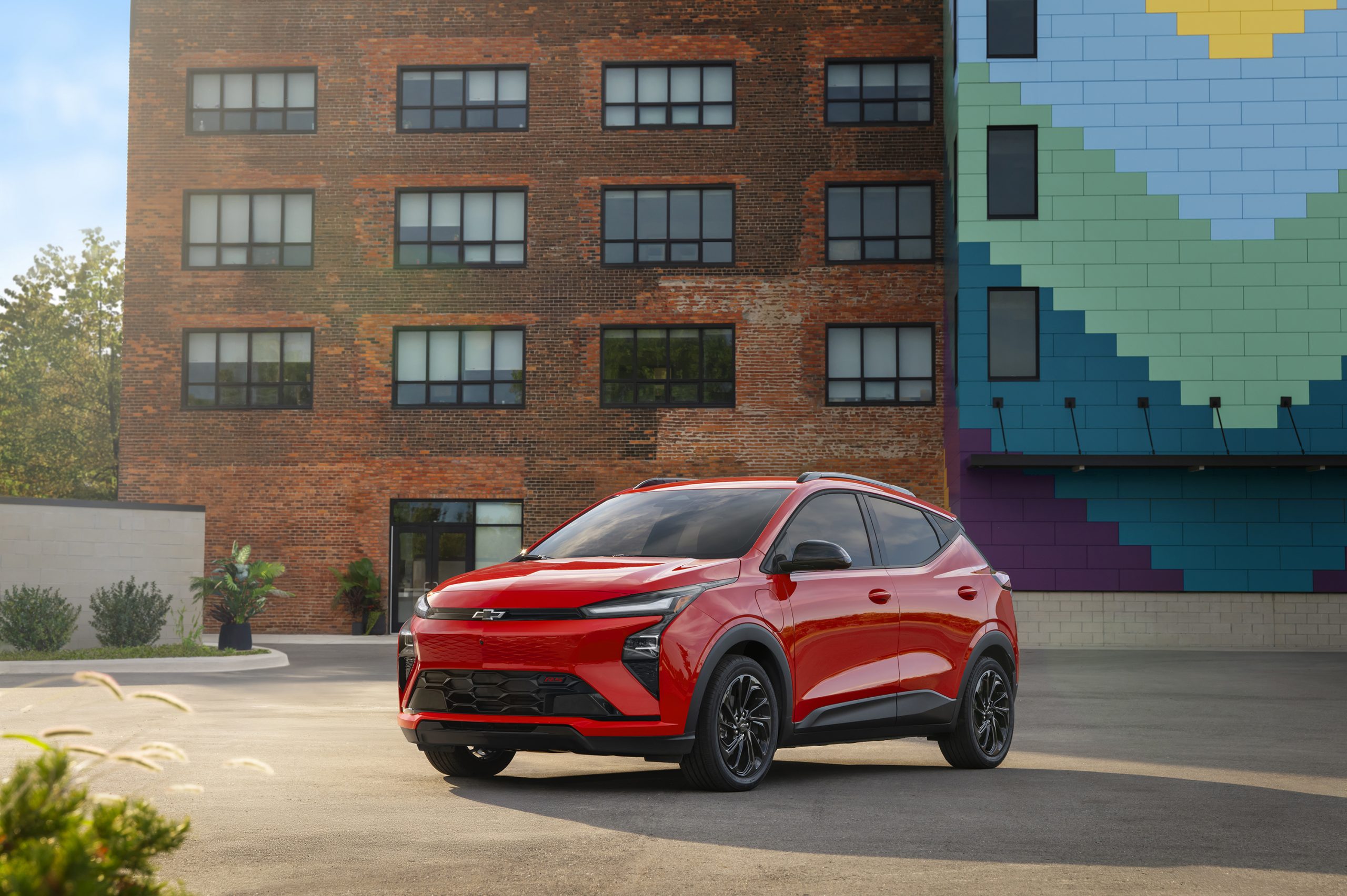 2027 Chevrolet Bolt front driver side angle showing modern LED headlights and aerodynamic design in blue