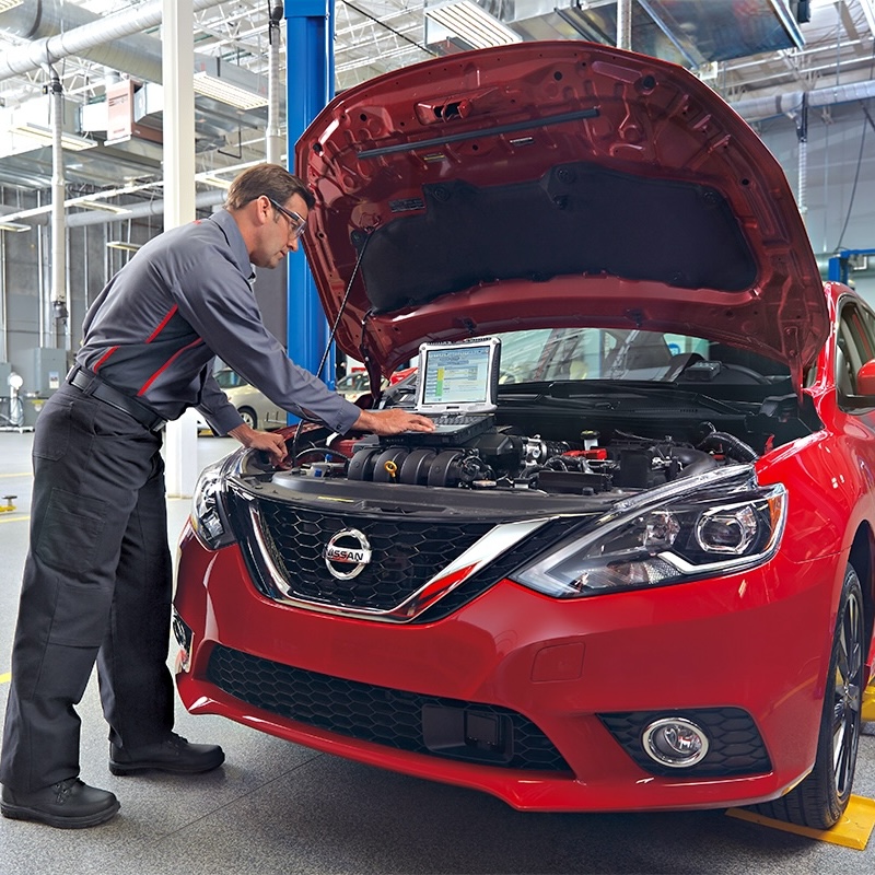 service center technician workin on a car