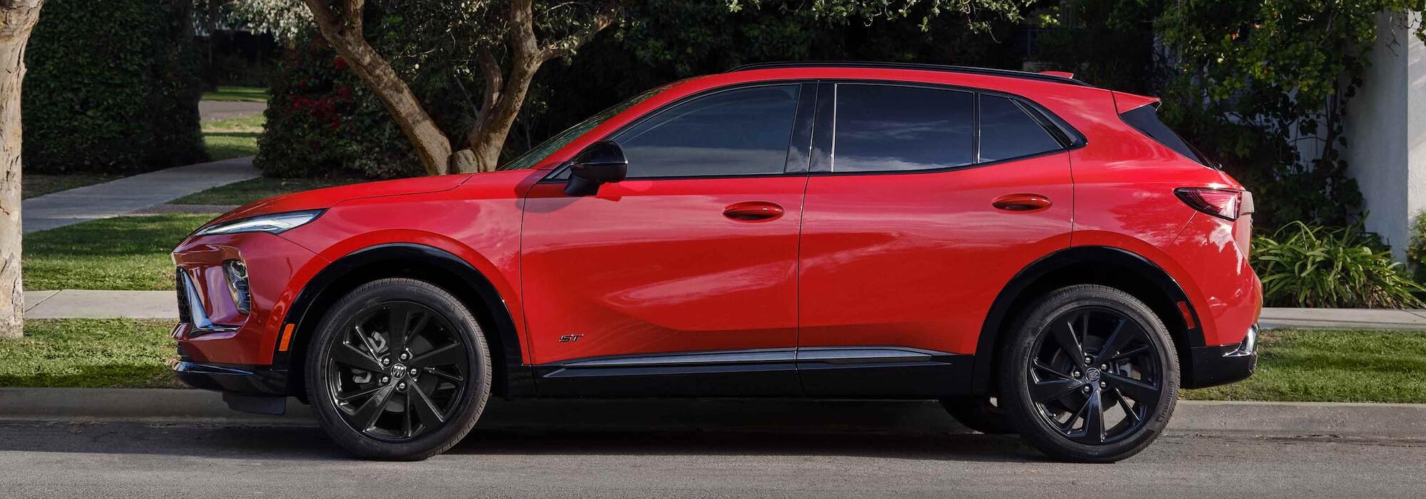 Side profile of a red 2026 Buick Envision ST with black alloy wheels