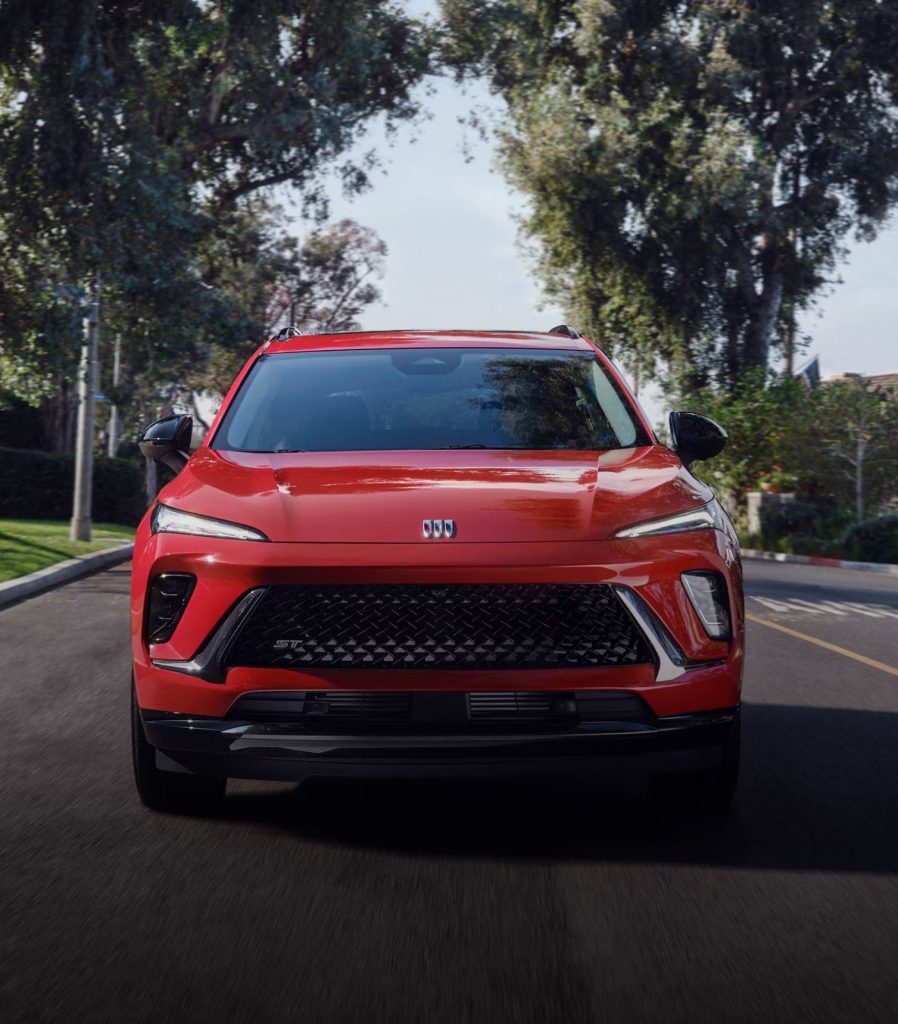 Front view of a red 2026 Buick Envision ST driving through a neighbourhood