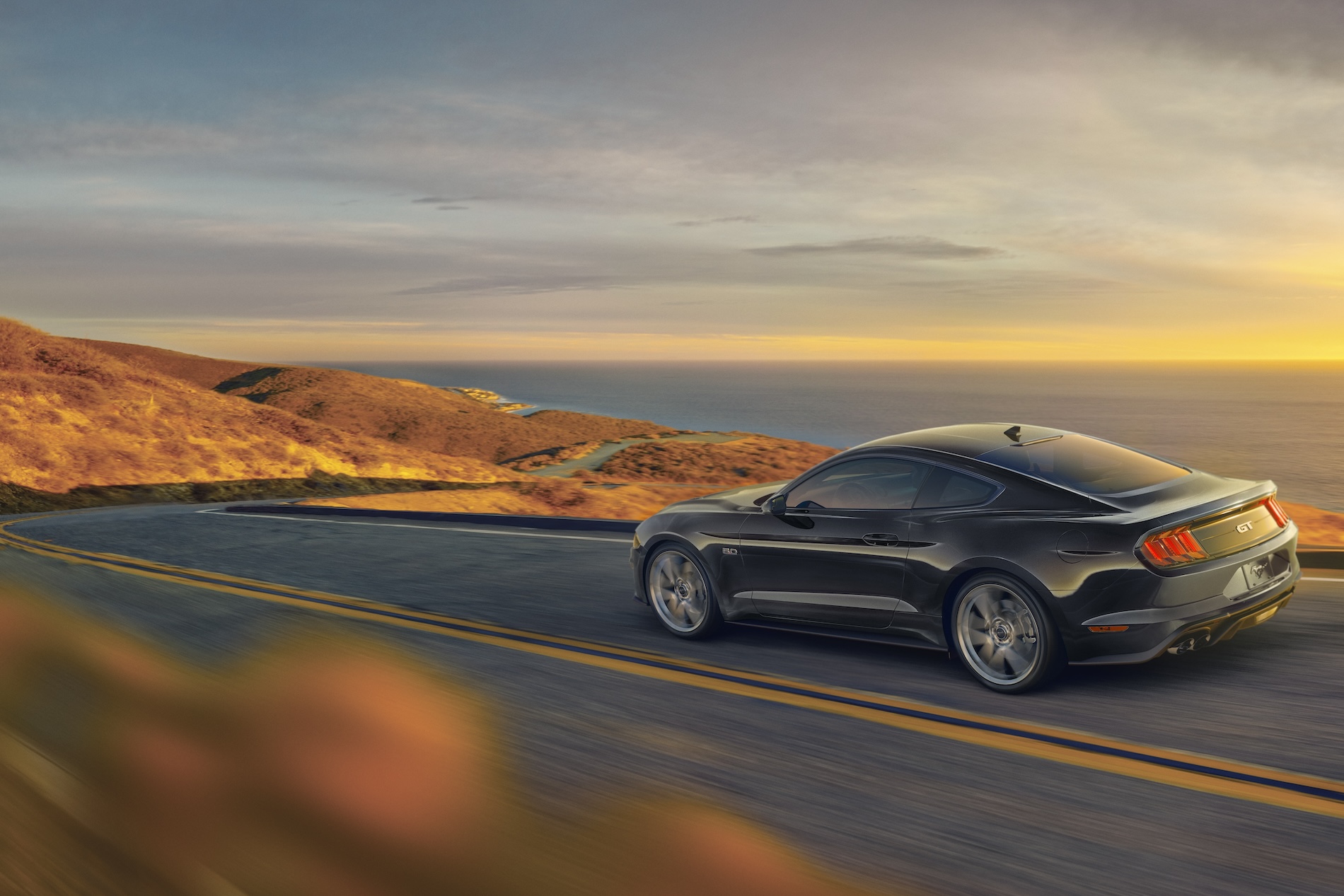 Ford mustang driving down a coastal road