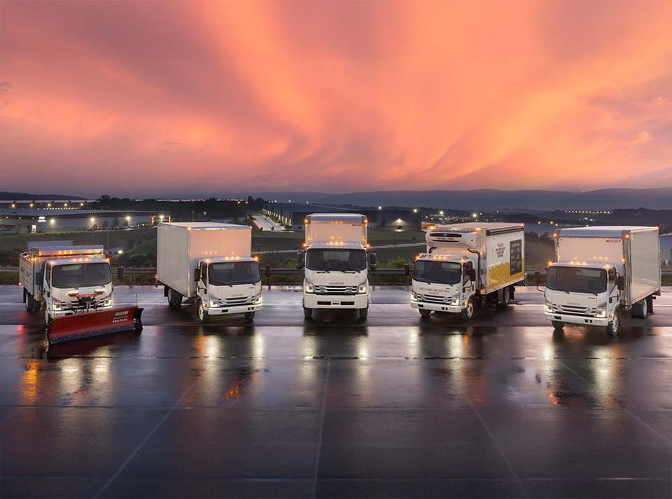 Isuzu vehicle lineup with sunset