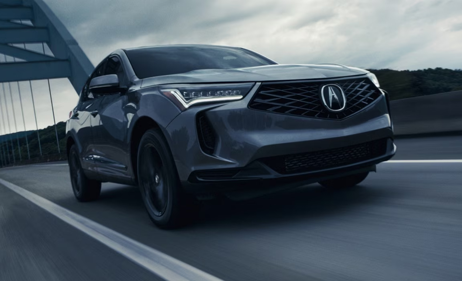 Grey Acura sedan driving on bridge road