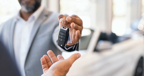 Salesperson handing over car keys to a customer