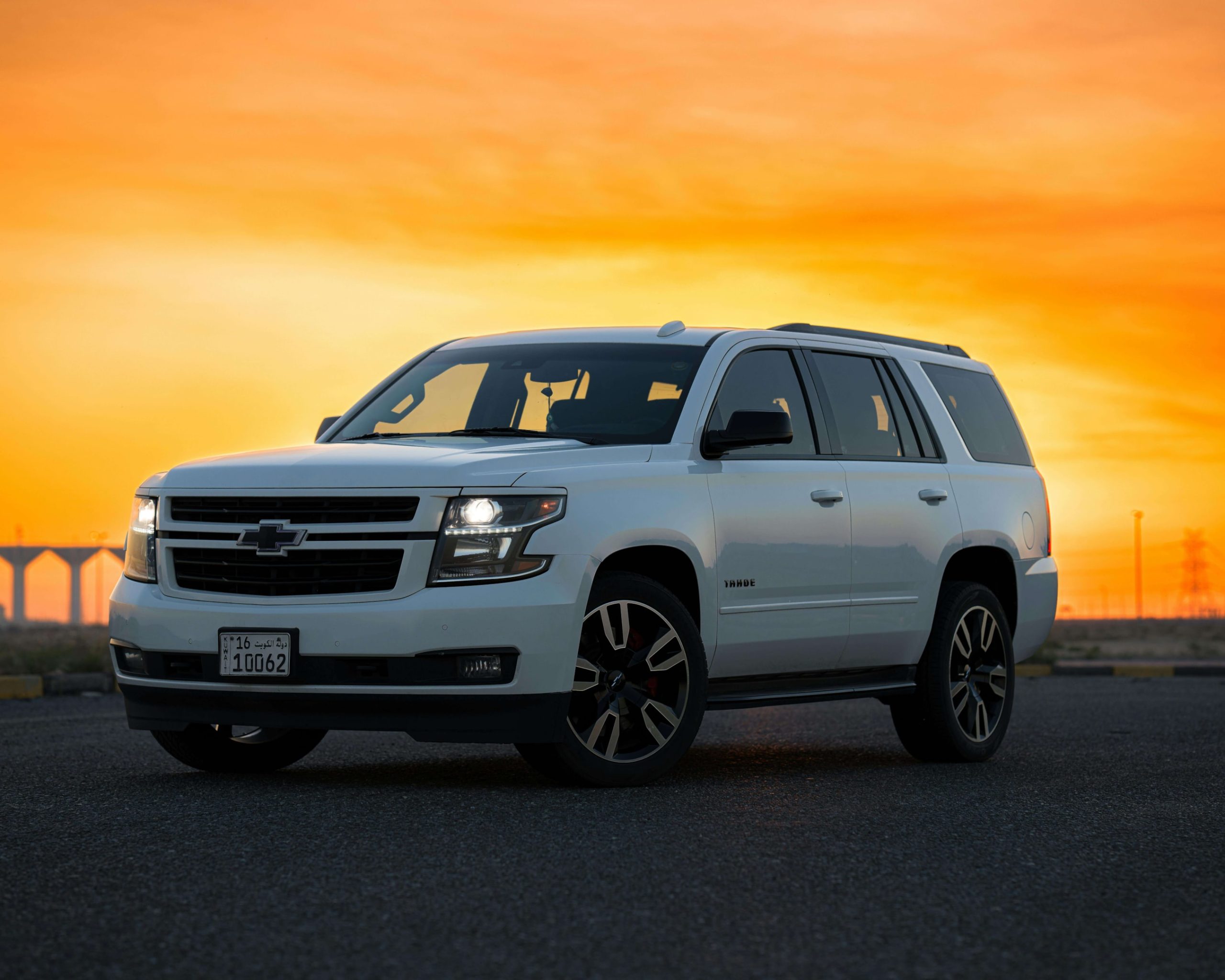 A Chevrolet Tahoe parked on a street, backed by an orange sunset.