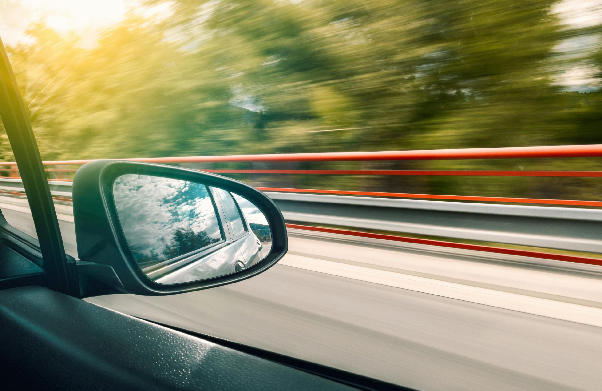 The view from the passenger side of a vehicle driving down an Ontario road in springtime