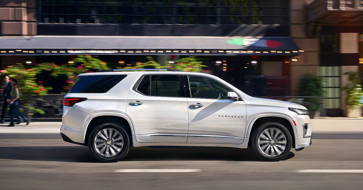 A white Chevy Traverse on the road