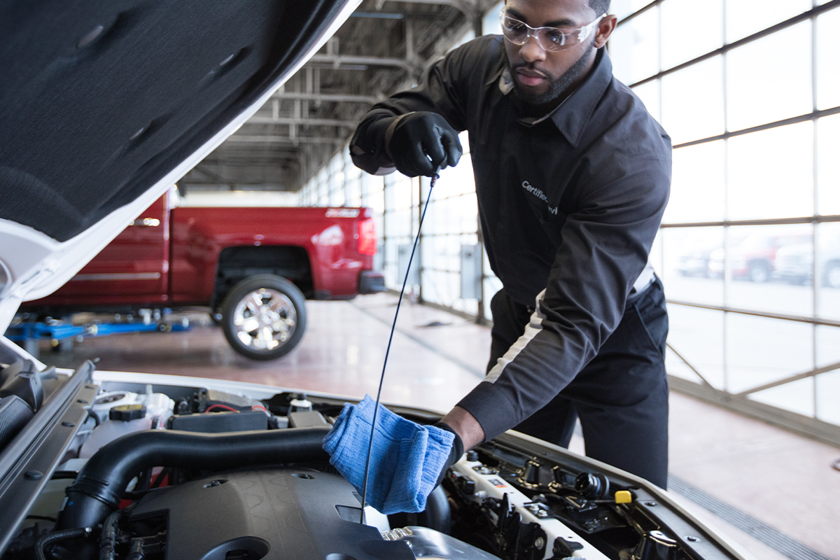 Chevrolet service technician checking the oil on an engine