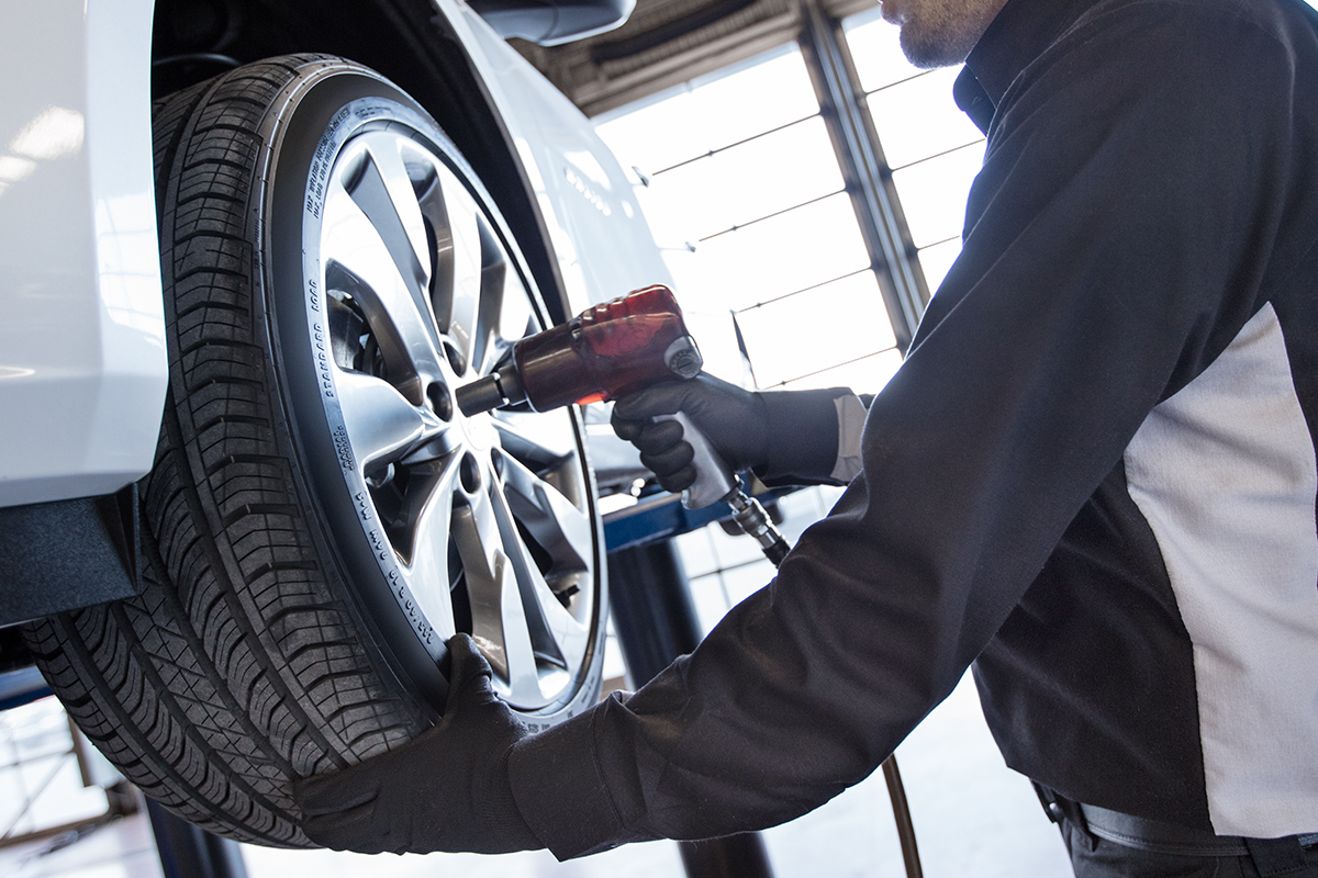 service technician replacing the tire on a Chevy