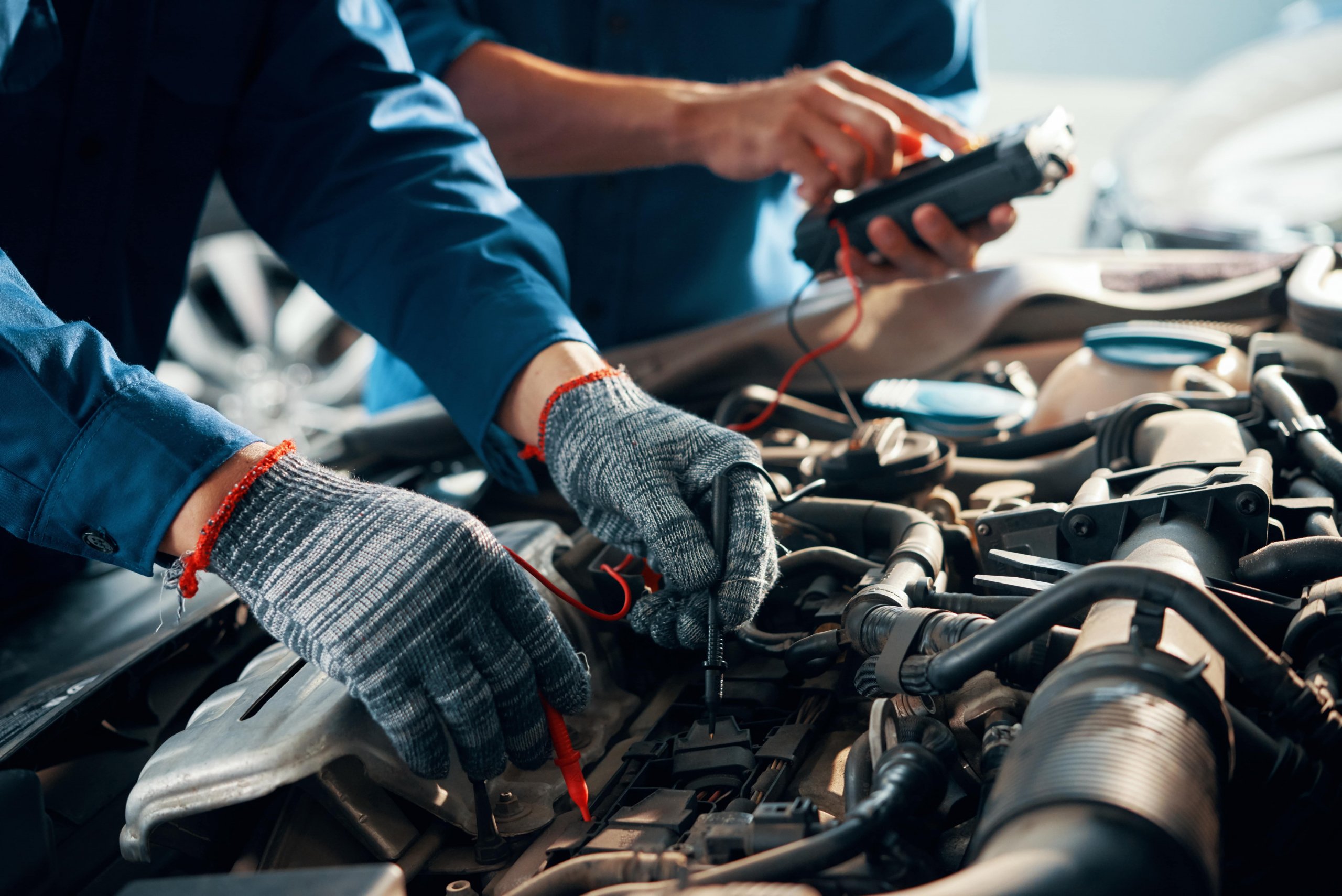 mechanic testing the levels on a car battery