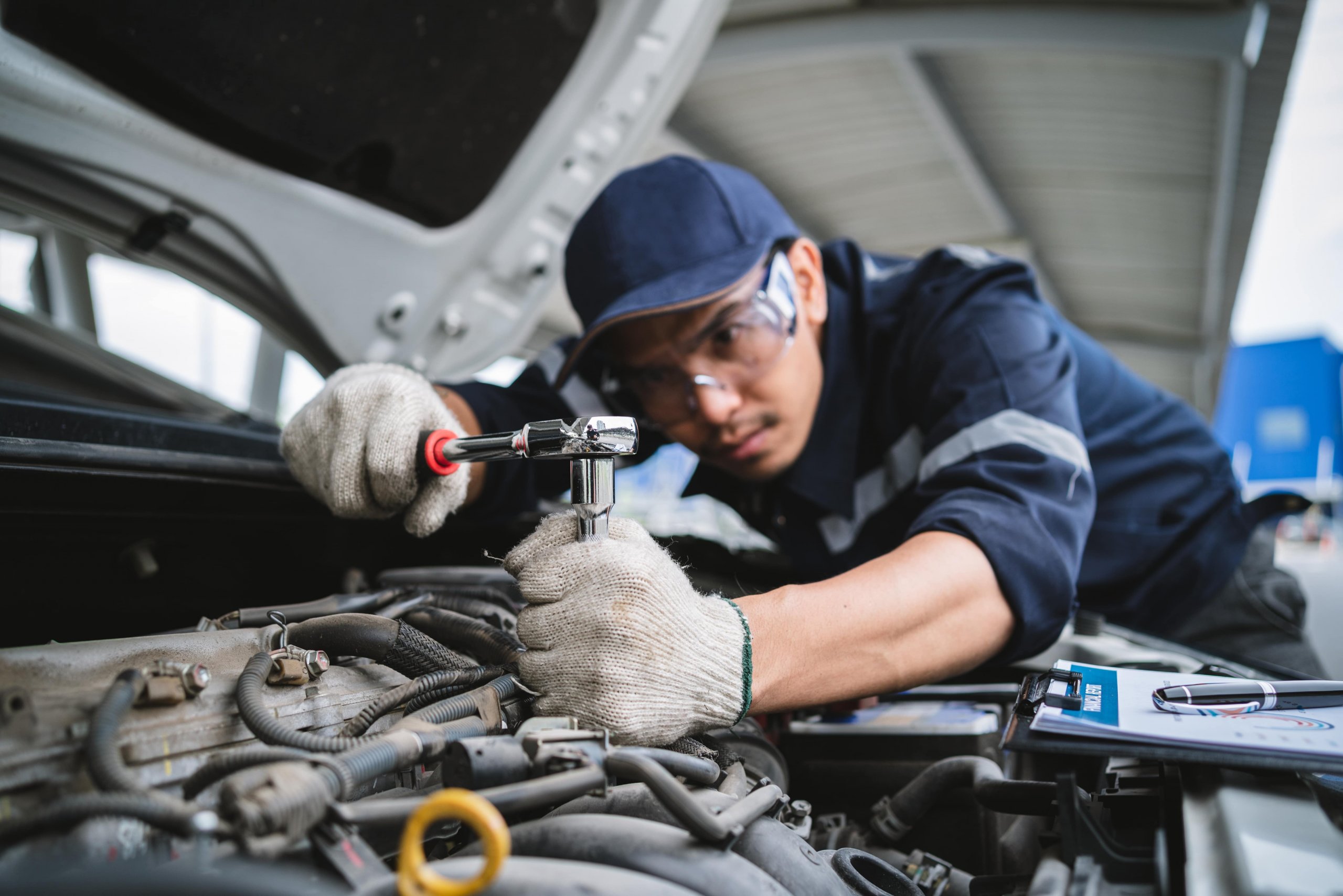 Mechanic tightening something in the engine of a chevy