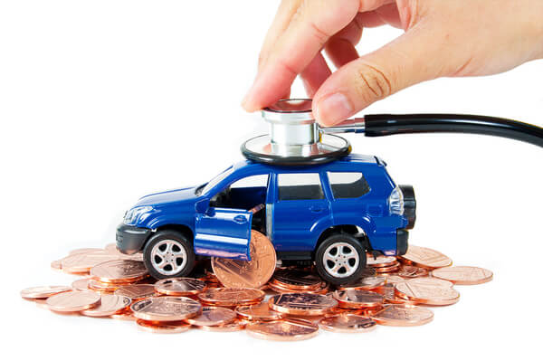 Toy car with a stethoscope on top of stacks of coins