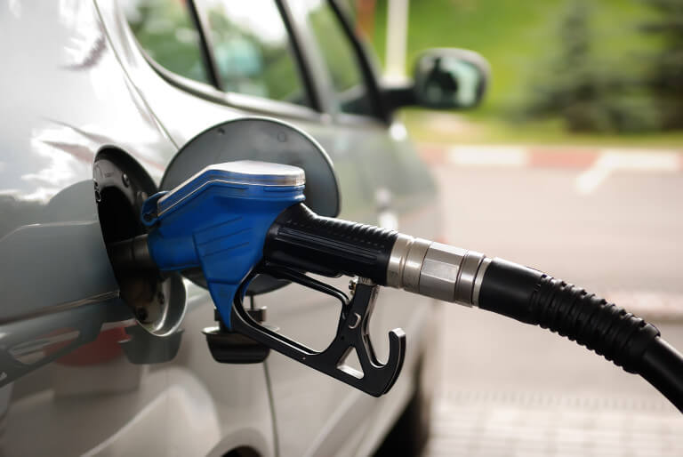 fuelling nozzle inserted into petrol tank at gas station for gasoline filling