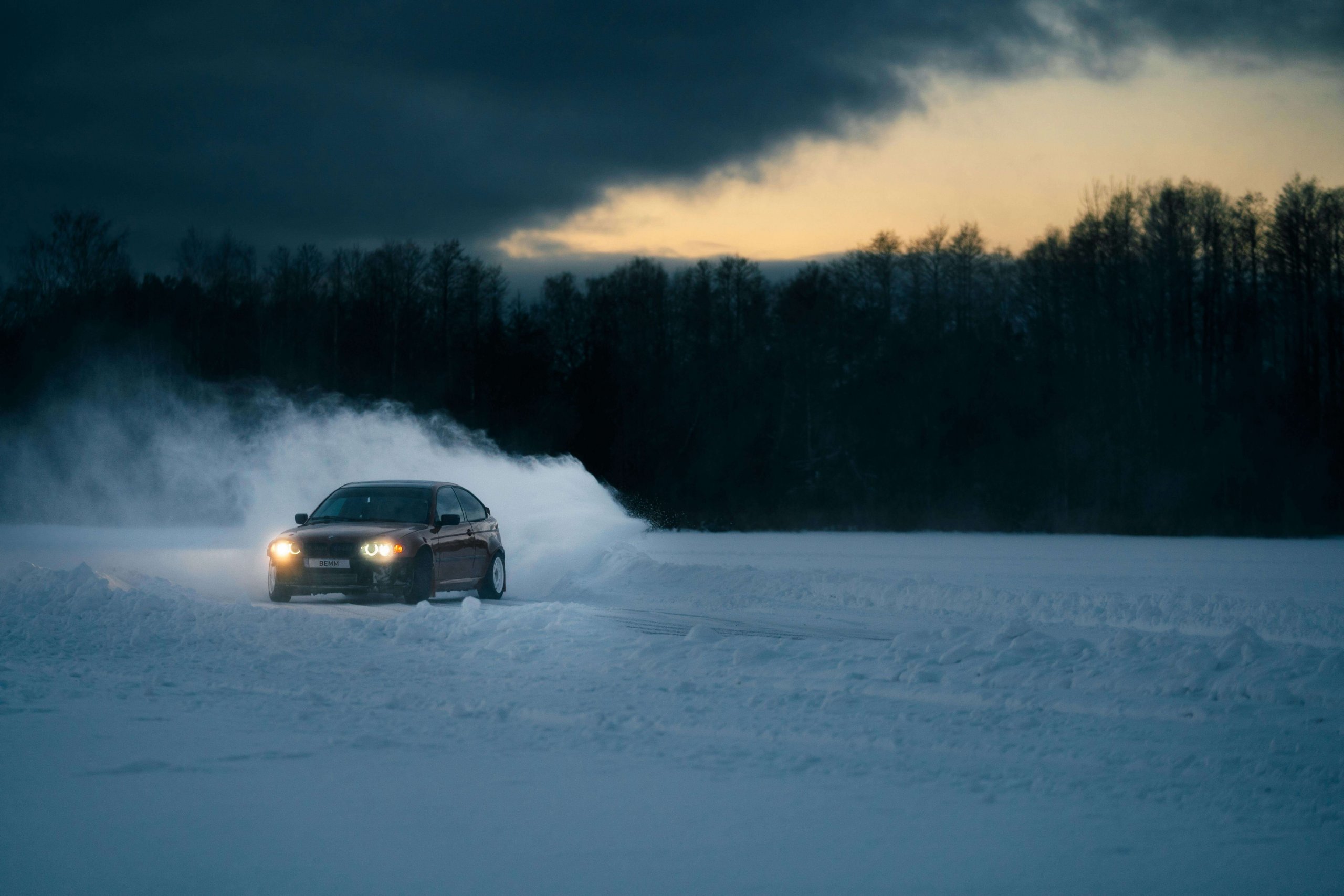 A car drifting in the snow, aided by specialty tires.