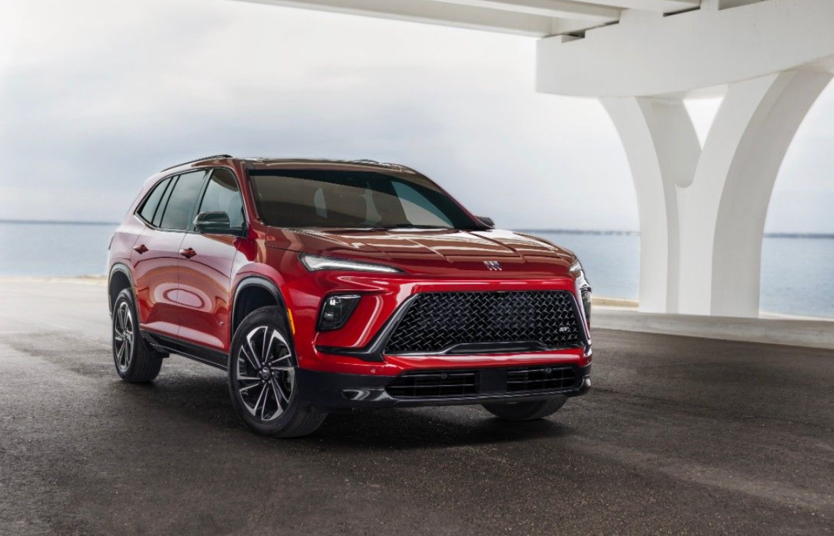 a promotional 3/4 front profile of a new red buick enclave near white pillars