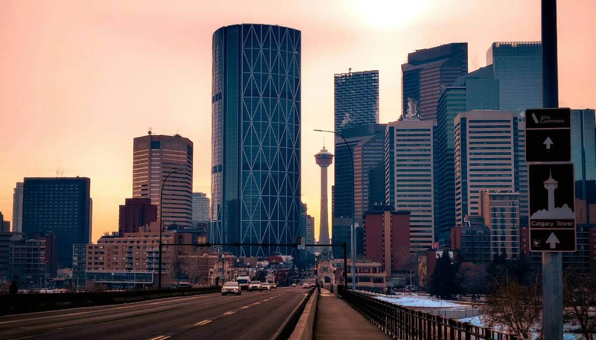 An iconic Calgary street with cars driving over the Bow River on a cold winter day at sunset