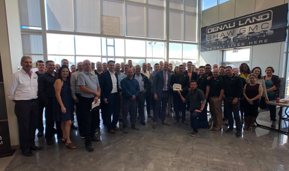 A staff photo of Shaw GMC from social media inside the dealership and on the sales floor, with Kaizen Auto Group leadership present