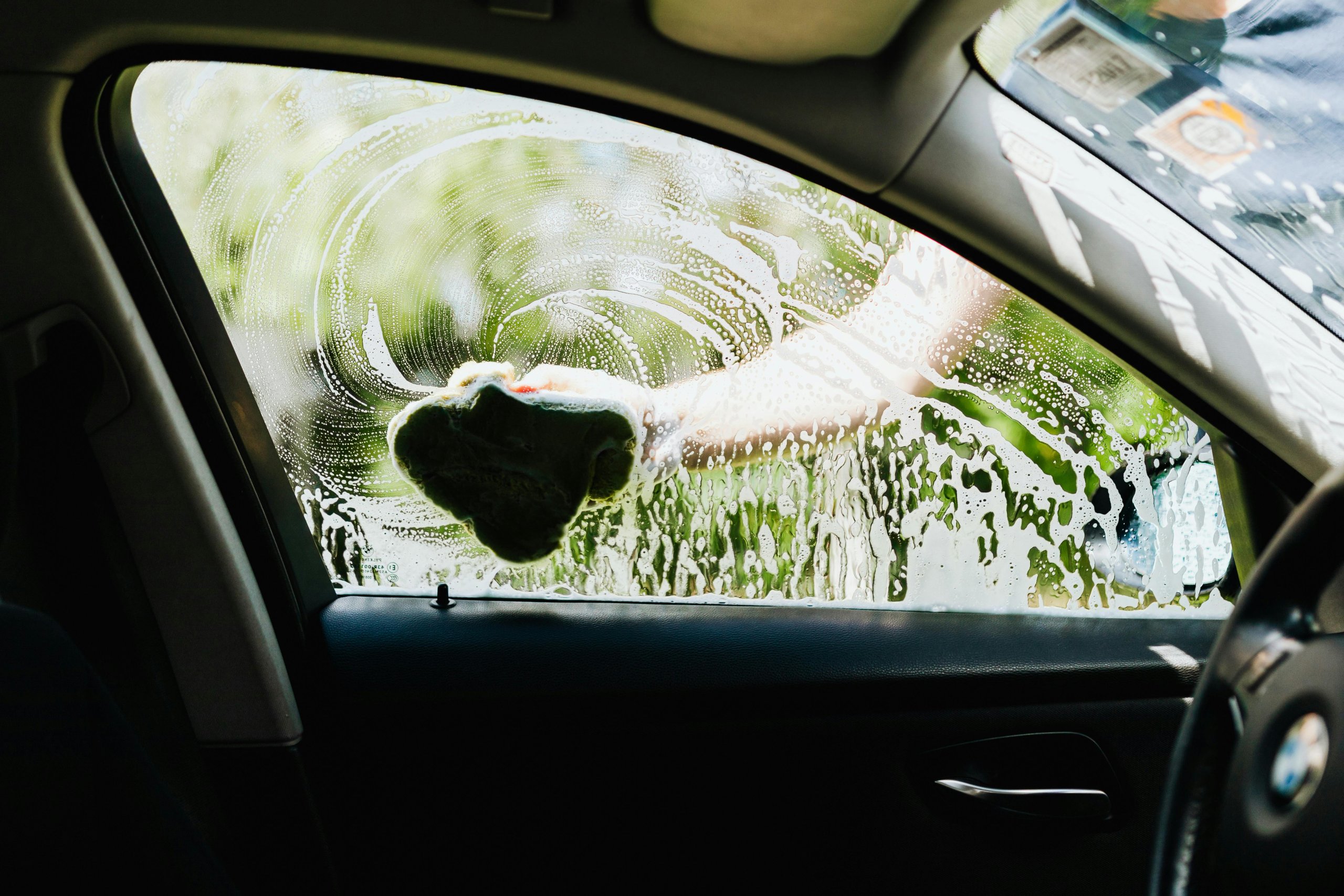 A person washing the window of their vehicle