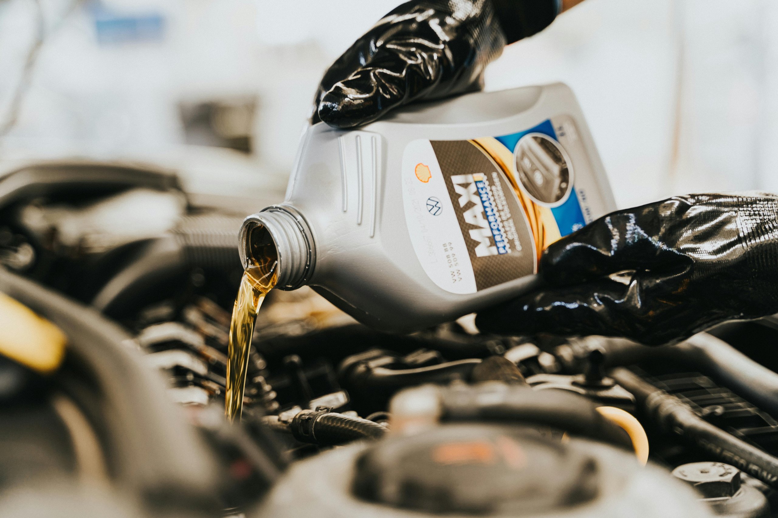 Close up of engine oil being poured into a vehicle