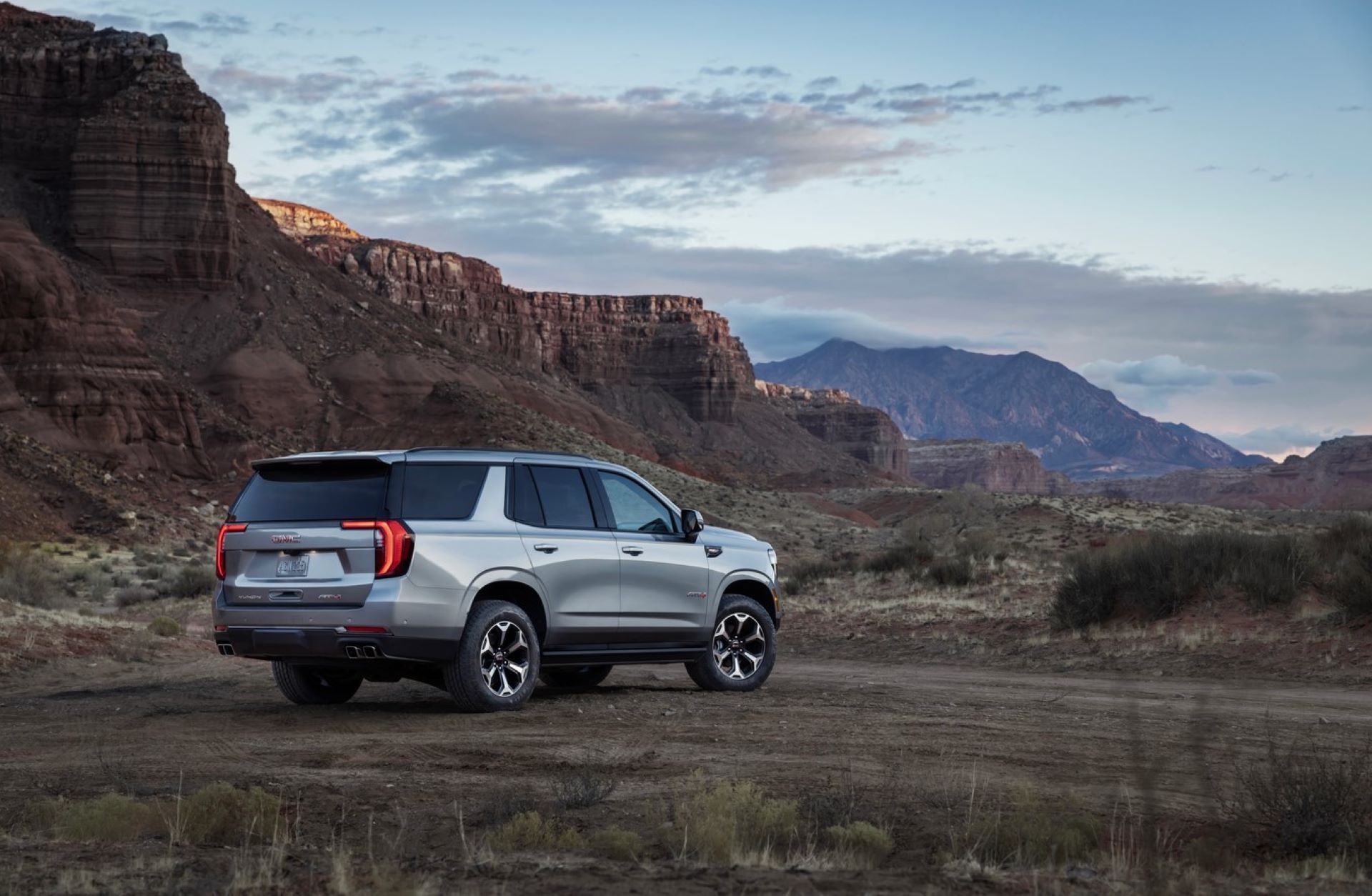 a new GMC Yukon AT4 Ultimate offroad in the Rocky mountains after spring.