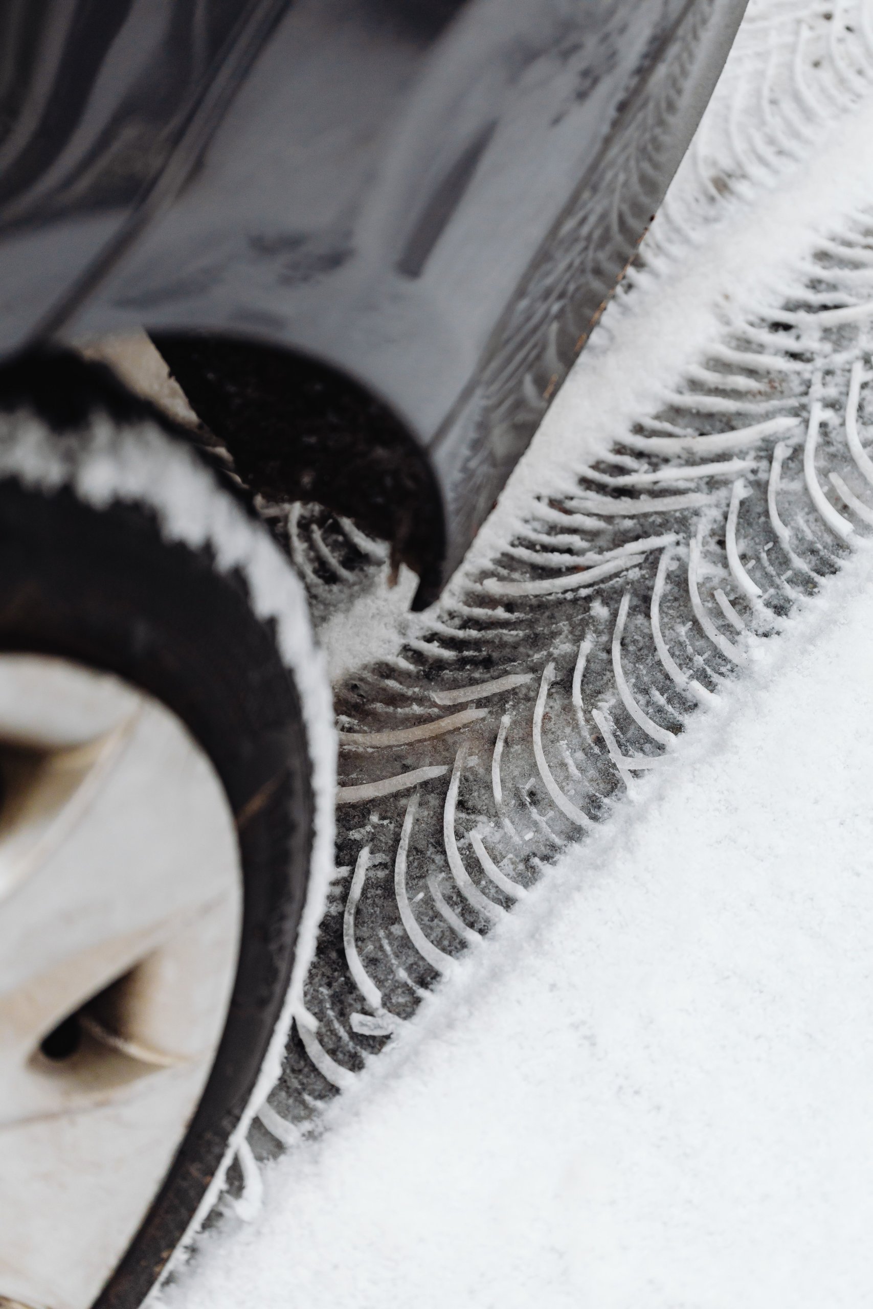 A close-up view of winter tires shows snow packed in the treads, emphasizing the importance of proper vehicle maintenance for safety and performance during winter driving. Maintaining quality tires is essential for car owners to ensure optimal fuel efficiency and vehicle handling in snowy conditions.