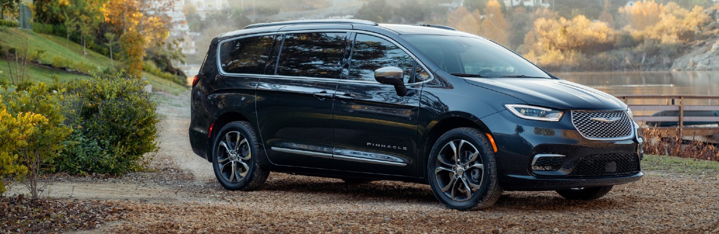 2021 Chrysler Pacifica Pinnacle exterior side shot parked on fallen leaves outside a farm and lake