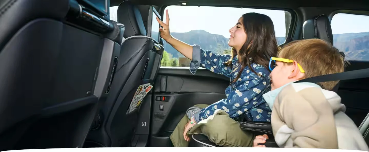 Kids riding in the second row of a 2027 Chrysler Pacifica on a family road trip