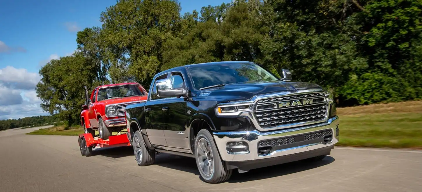 black Ram 1500 Limited towing a vintage car on a trailer