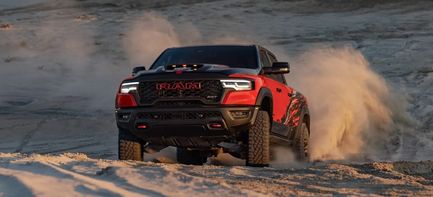 2027 Ram 1500 TRX in red running head-on through the desert at golden hour
