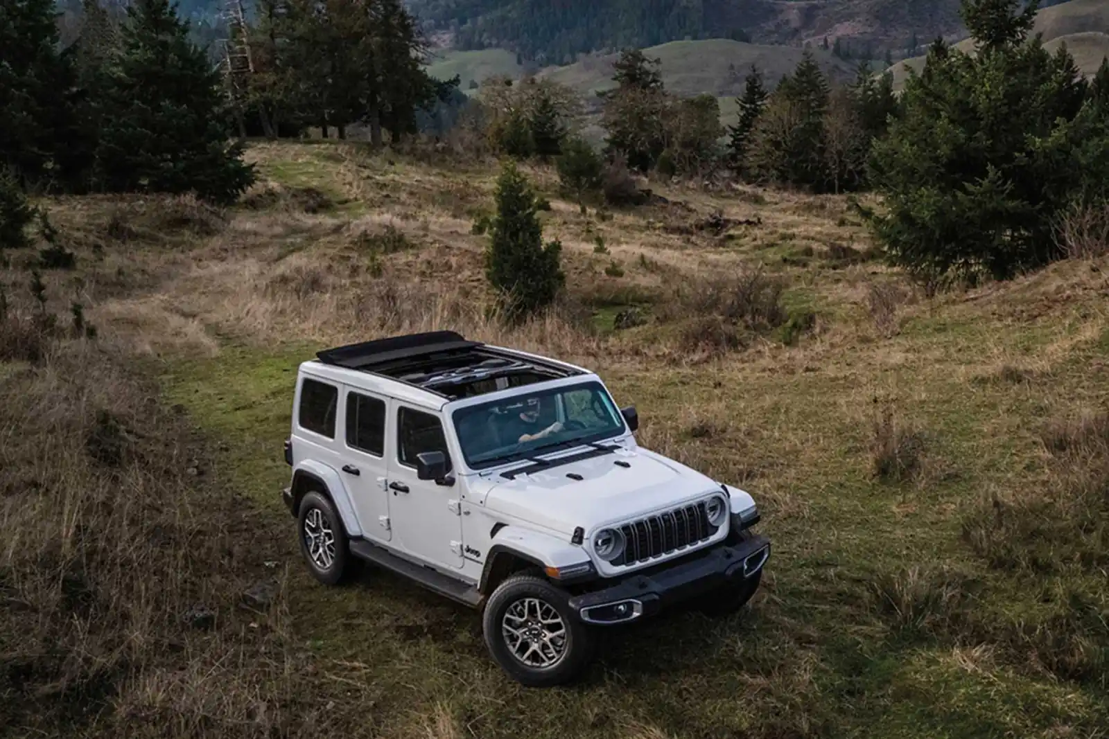 white 2026 Jeep Wrangler front three quarter view in an open field
