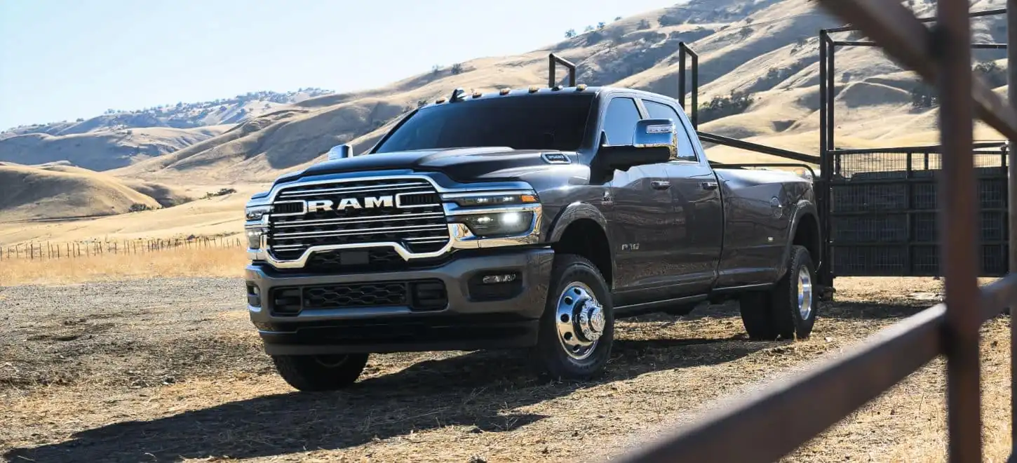 dark grey Ram 3500 dually parked beside a livestock corral in golden hills
