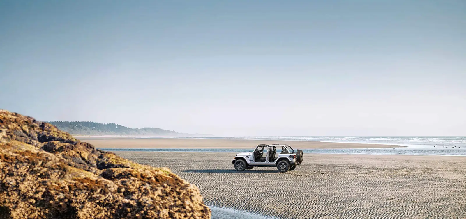 2026 Jeep Wrangler exterior side profile in an outdoor off road setting