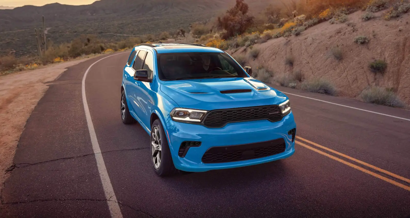 blue Dodge Durango front three quarter driving on an open highway