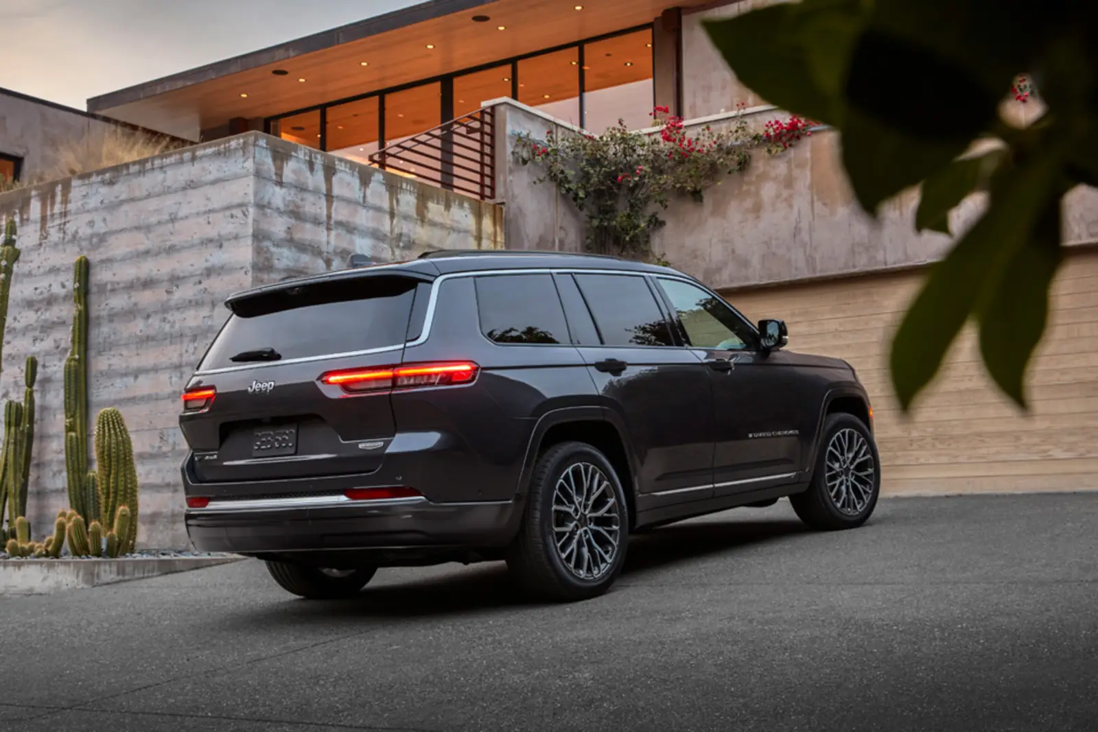 Blue 2026 Jeep Grand Cherokee rear three quarter view driving on a highway