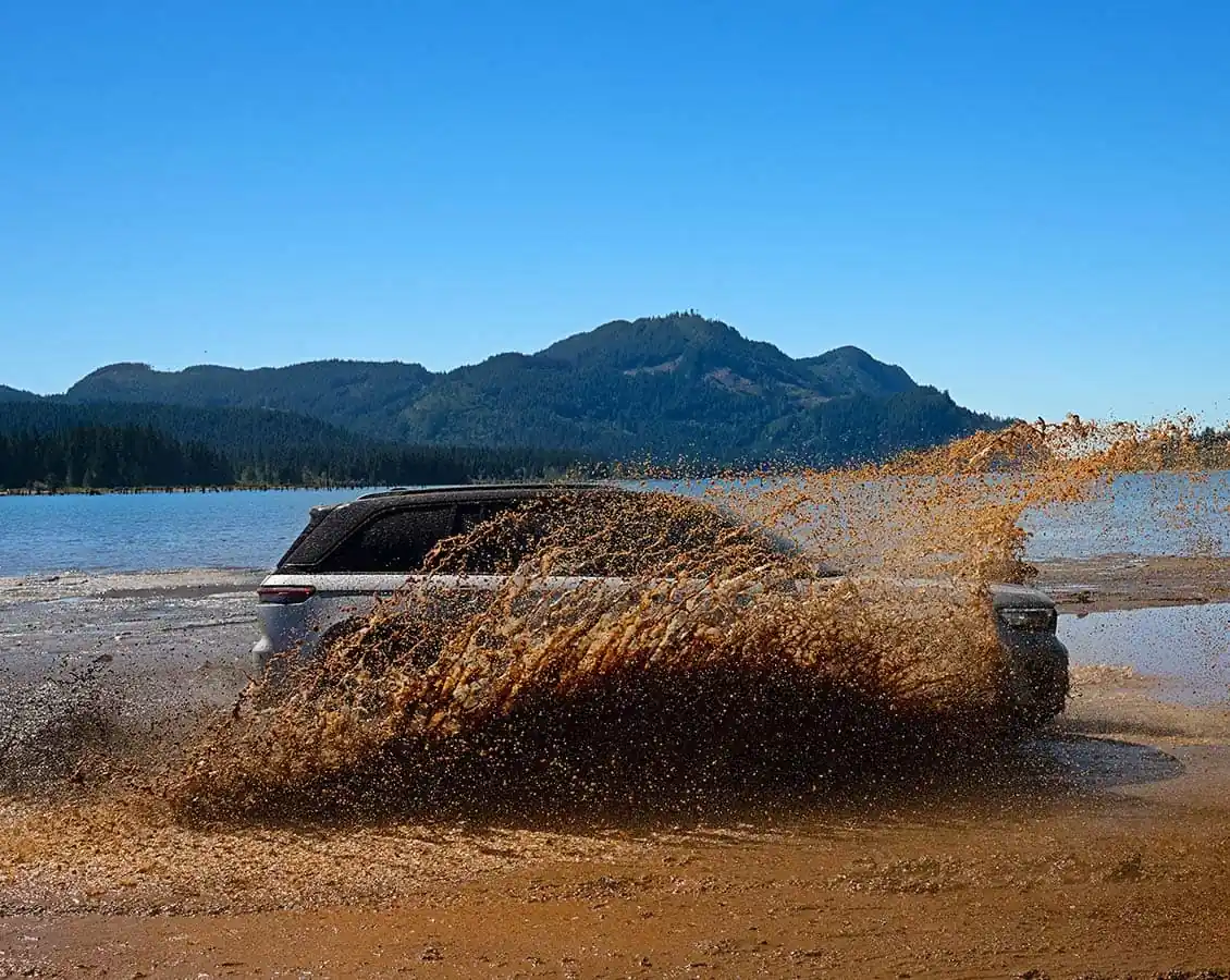 2026 Jeep Grand Cherokee driving through a water crossing, side profile