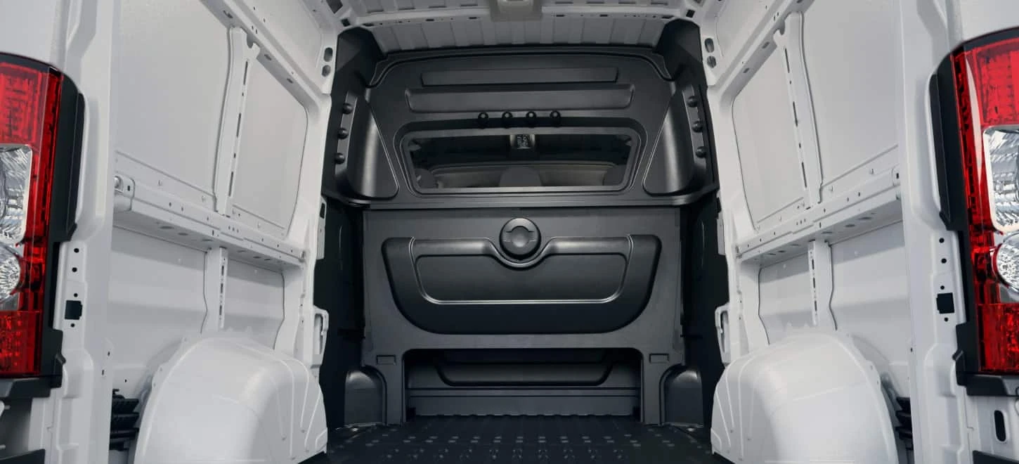 Empty Ram ProMaster cargo bay viewed from the open rear doors looking toward the bulkhead