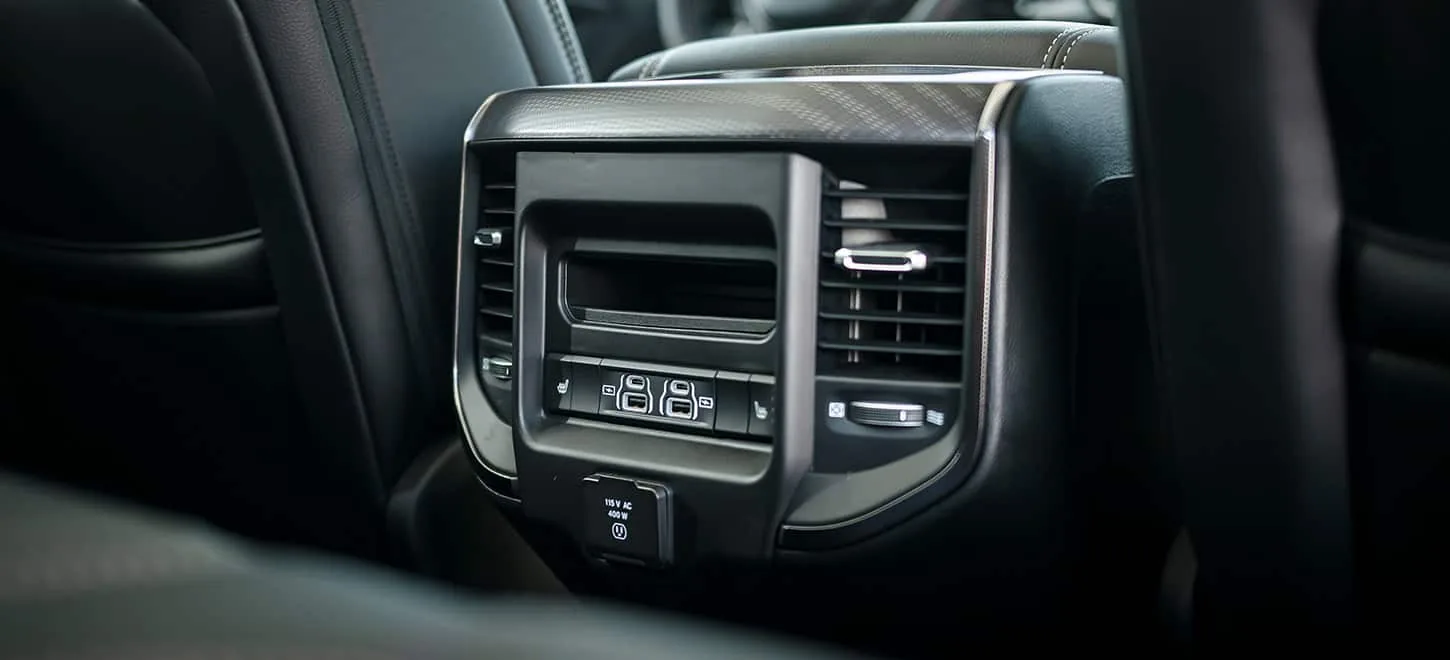 Ram 1500 rear seat air vents and 115 volt power outlet in a black leather interior