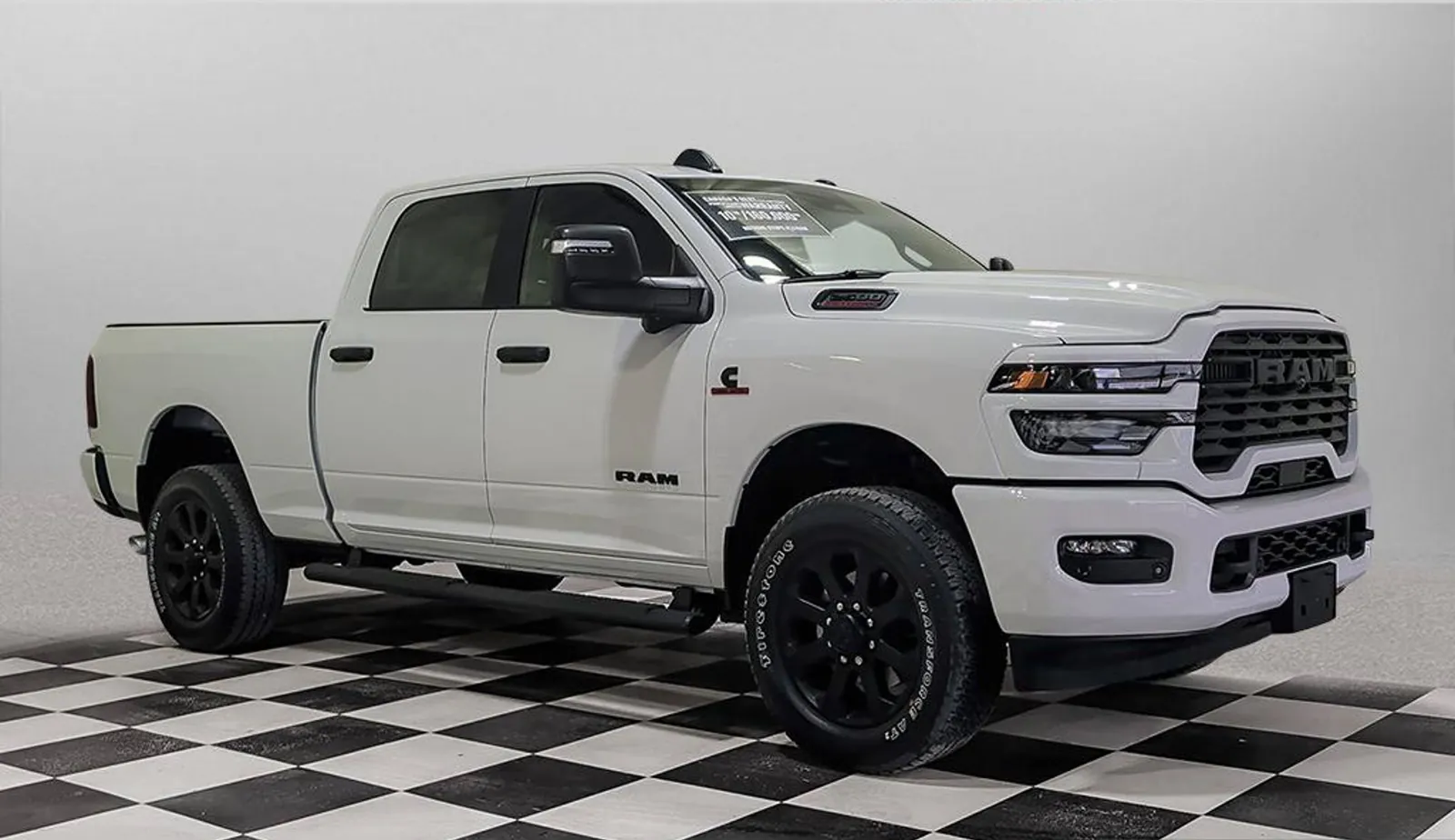 White 2026 Ram 2500 Big Horn Crew Cab front three quarter on the dealer lot