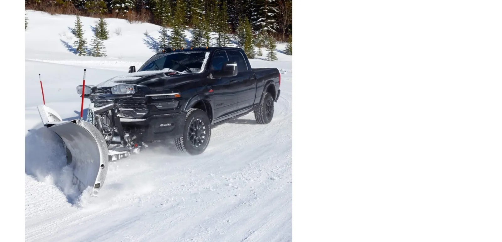 Black Ram 2500 pushing a snow plow on a snowy treed road