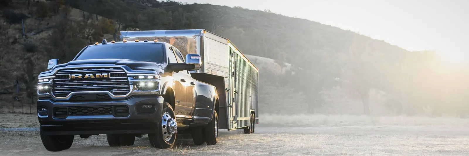 Dark Ram 3500 dually towing an aluminum livestock trailer on a frosty morning