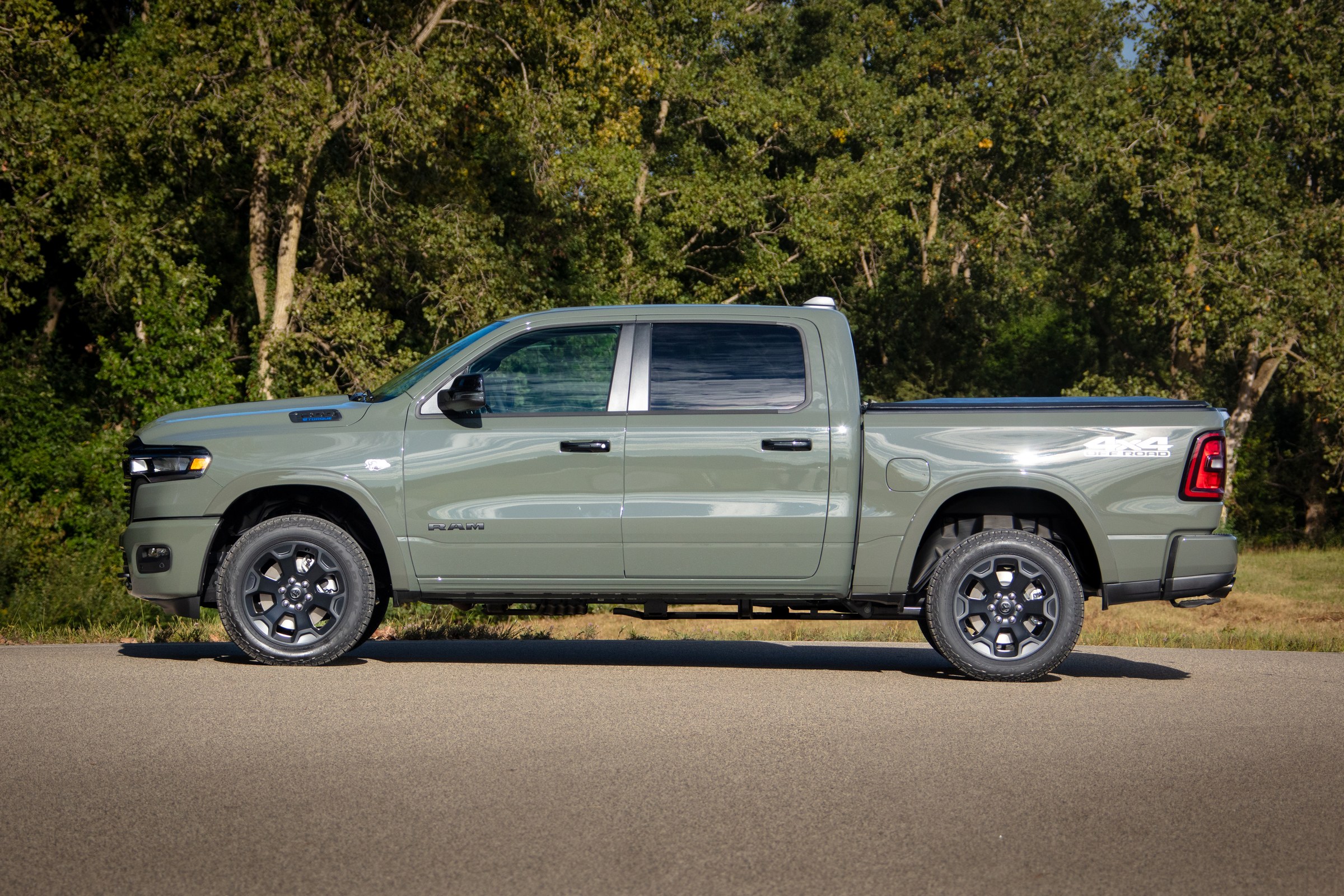 Ram 1500 Big Horn crew cab side profile on a farm lane