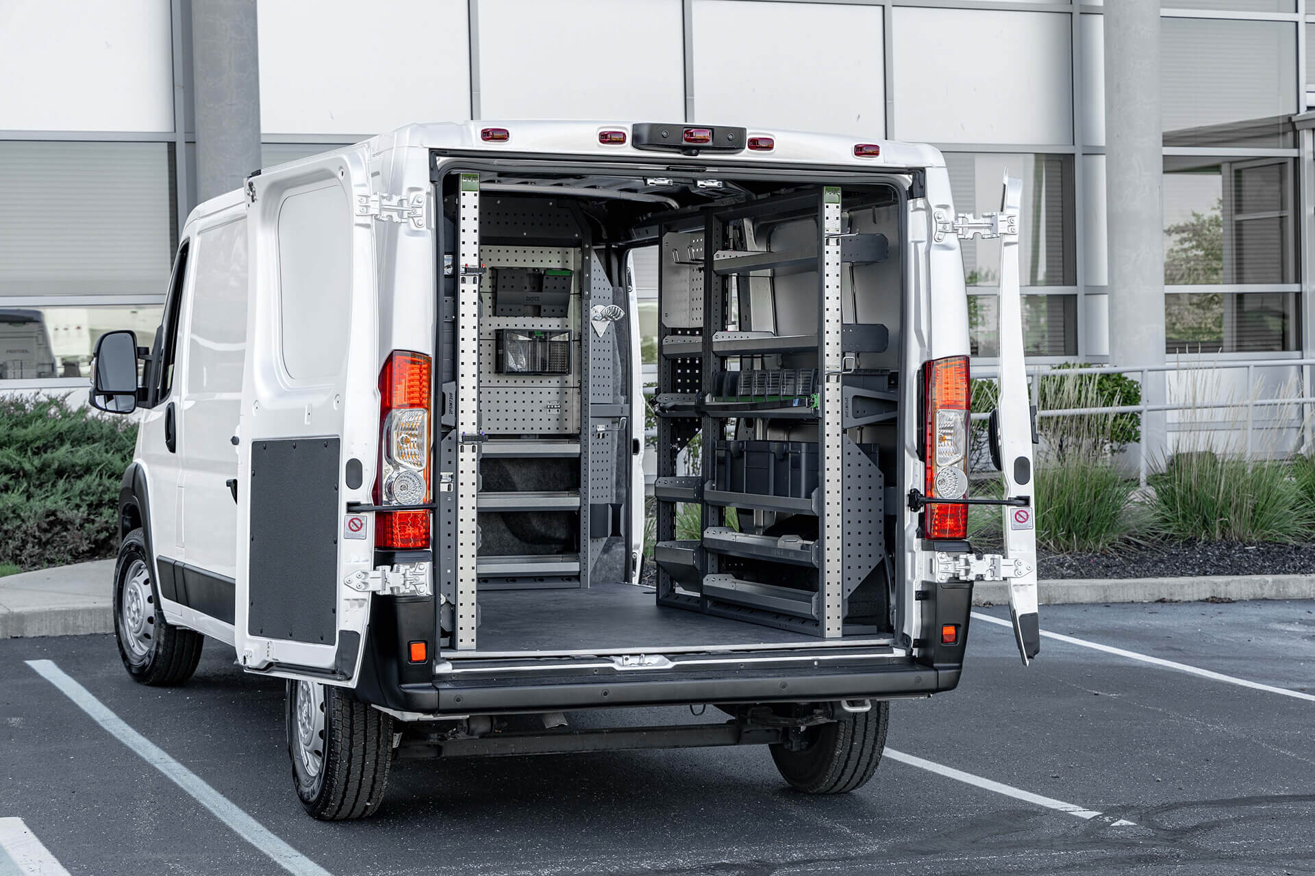 white Ram ProMaster with rear doors open showing fitted racking and parts drawers